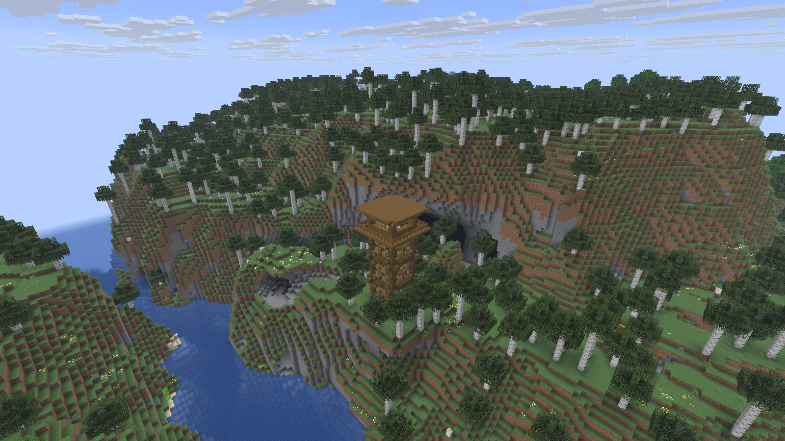 A wooden firetower stands above a river between steep birch-covered hills.