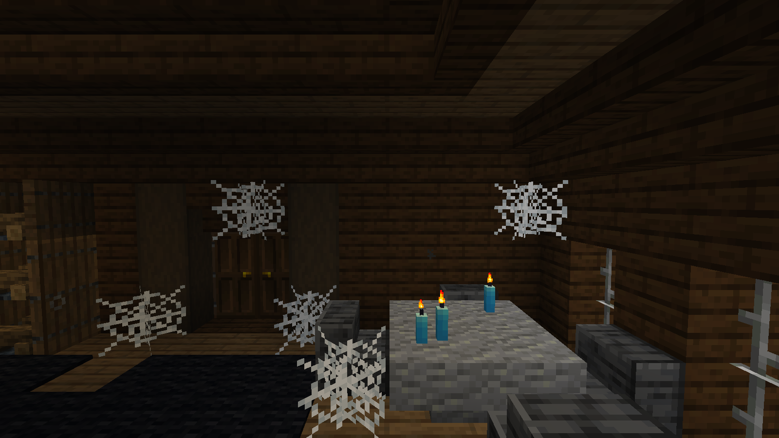 Blue candles stand on a table in an upper manor room surrounded by cobwebs and dark wooden walls.