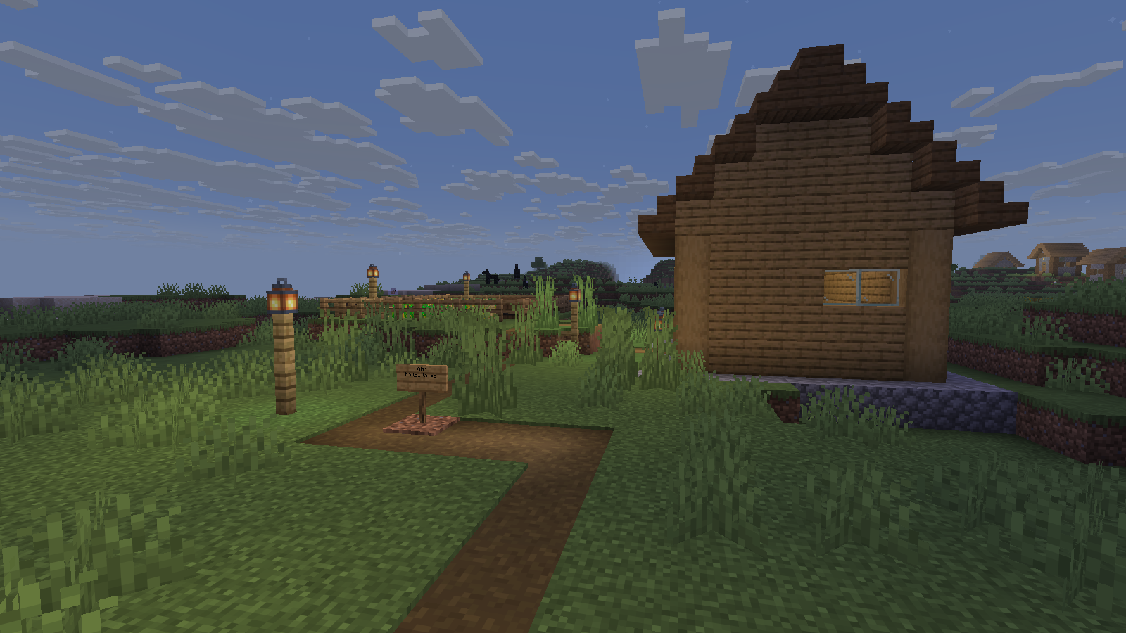A lit turn and home sign beside a completed wooden cottage at dusk.