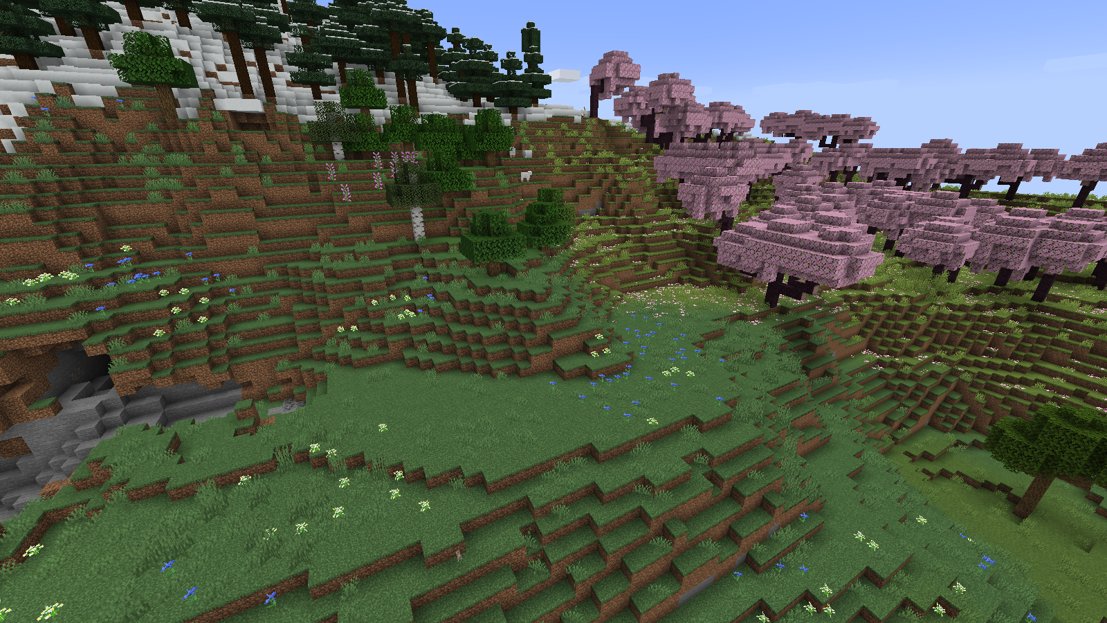 A cherry grove clearing beside stepped grassy slopes and a snowy forest in our Tectonic world.