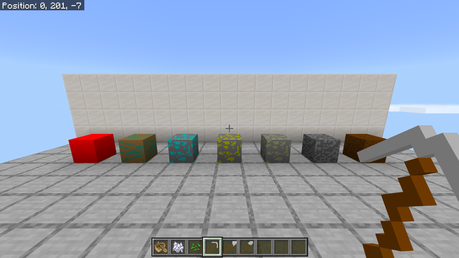 First-person view of CheapDesign iron pickaxe with a flat gray head and brown handle, beside three iron tool icons in the hotbar.