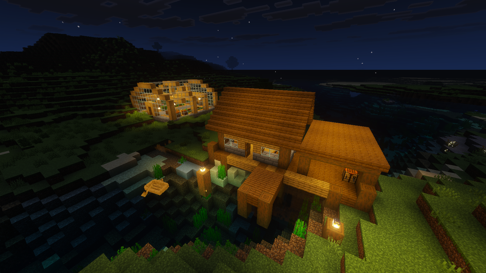 Night view of the warehouse and pier, lit warmly against dark water with Full Vanilla Vibrant Visuals.