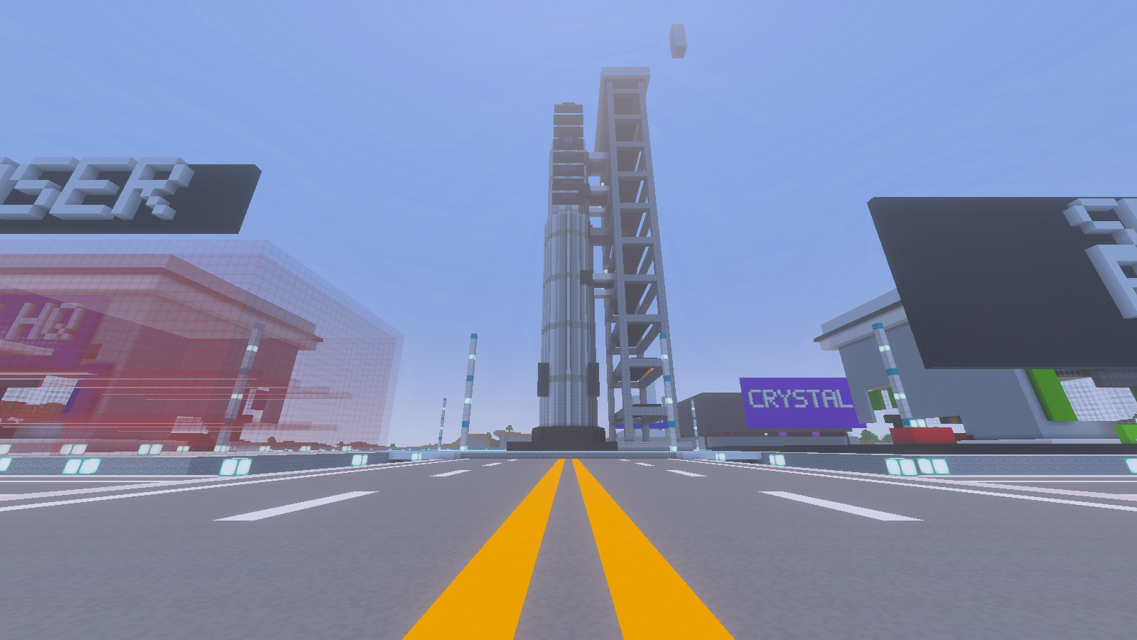A yellow-lined road facing a rocket and open-frame tower, with a detached block column visible above.