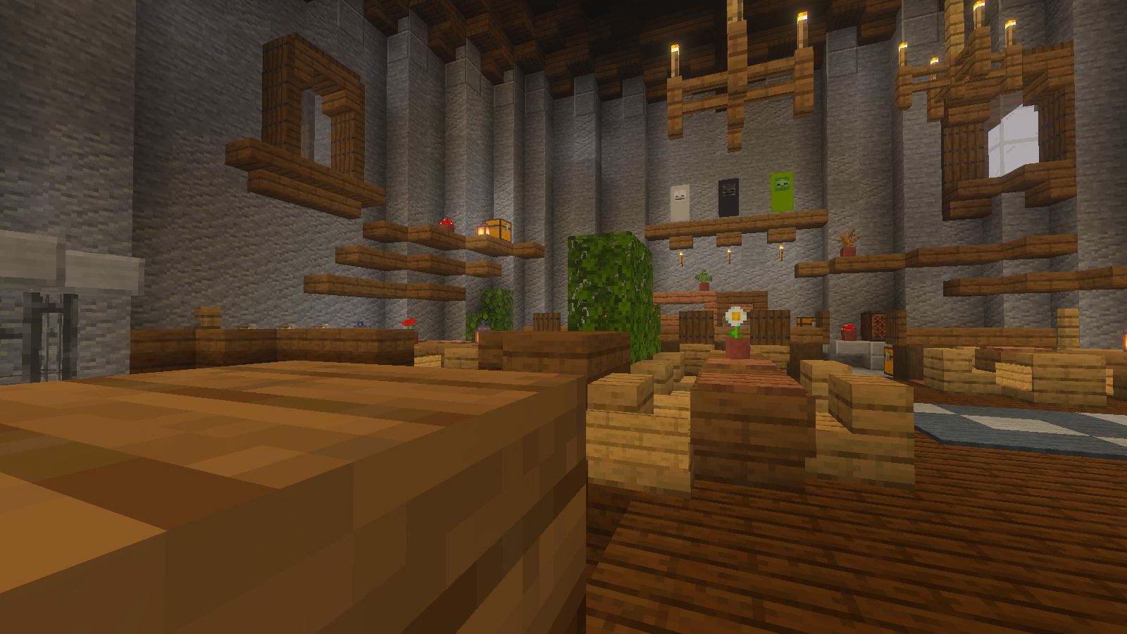 Tavern dining hall with wooden tables and benches, hanging lights, banners and plants.