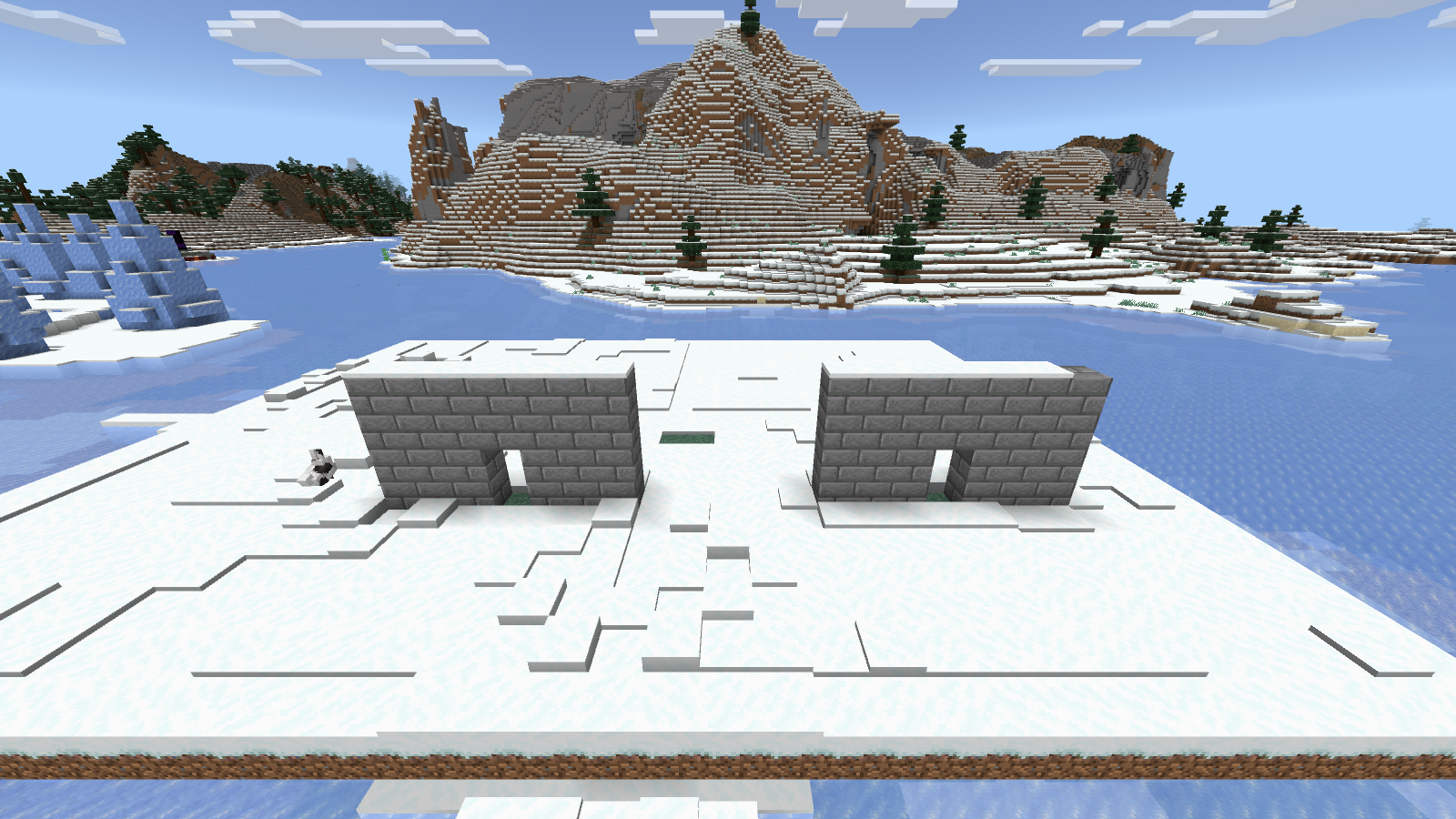 Two stone-brick wall sections with matching doorways on our snowy Bedrock practice plot.